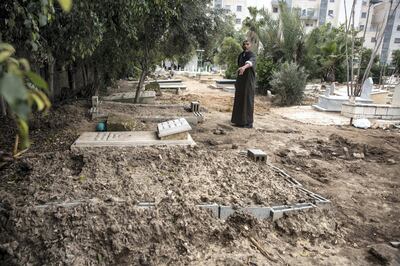A Muslim cemetery care taker points to the fresh grave of  of Diana Abu Qatifan, 18, that is marked  marked by concrete construction blocks nearby the grave of her mother who was also killed and buried  at the cemetery in Lod . Diana was gunned down while shopping for a wedding dress with her grandfather in Lod, adjacent to Ramle. Back in February, Abu Qatifan became engaged to a man of her choosing but who her parents rejected.
Her mother was murdered in 2006 in Lod. In that case, police arrested the mother's husband and recommended that he be charged in the case, but the prosecutor's office decided not to file charges.  
 (Photo by Heidi Levine for The National).