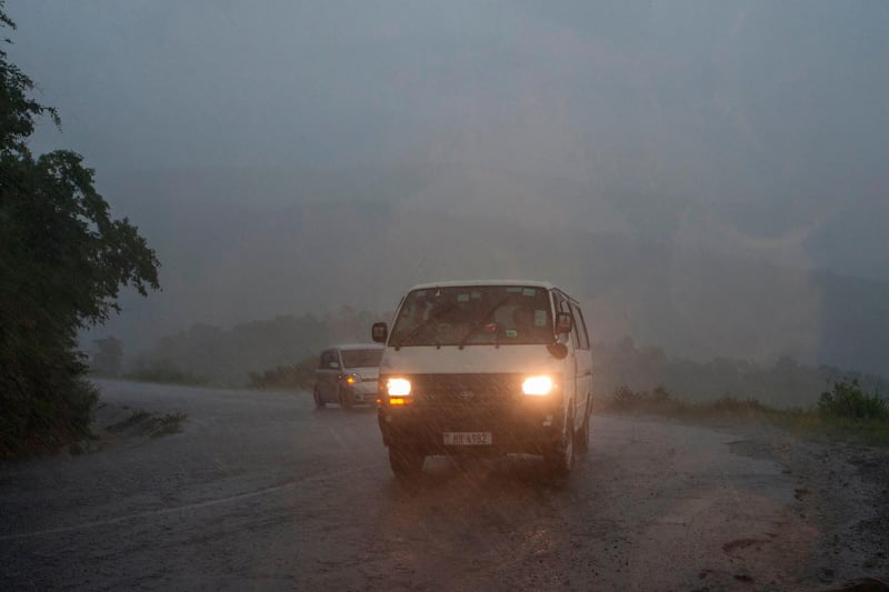 This picture taken on March 15, 2019 shows vehicules as rain, which is believed to be the beginning of Tropical cyclone Idai coming from central Mozambique, falls in the flooded districts of Chikwawaa and Nsanje in southern Malawi. At least 56 people have died in flood-hit areas as of March 13, according to the government, while 577 had been injured and almost 83,000 people have been displaced. / AFP / AMOS GUMULIRA
