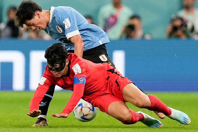 South Korea's Son Heung-min, below, and Uruguay's Facundo Pellistri battle for the ball. AP