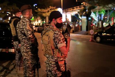 Lebanese security forces wearing protective masks to prevent the spread of coronavirus, as they stand guard at a street full of restaurants where revelers celebrating the New Year Eve, in Beirut, Lebanon, early Friday, Jan. 1, 2021. Lebanon ended the year with more than 3,500 newly registered infections of coronavirus and 12 new deaths as its health minister rang appealed to Lebanese to take precautions while celebrating to avoid what he called wasting sacrifices made in combatting the virus. (AP Photo/Hussein Malla)