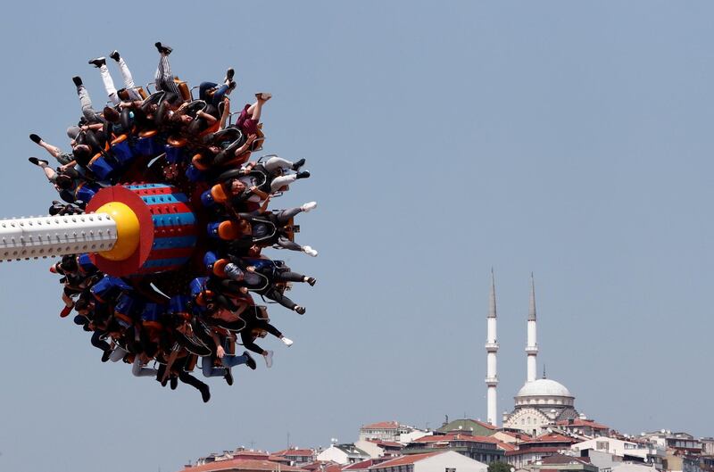 People enjoy a ride in an amusement park as they celebrate the second day of Eid Al Fitr in Istanbul, Turkey.