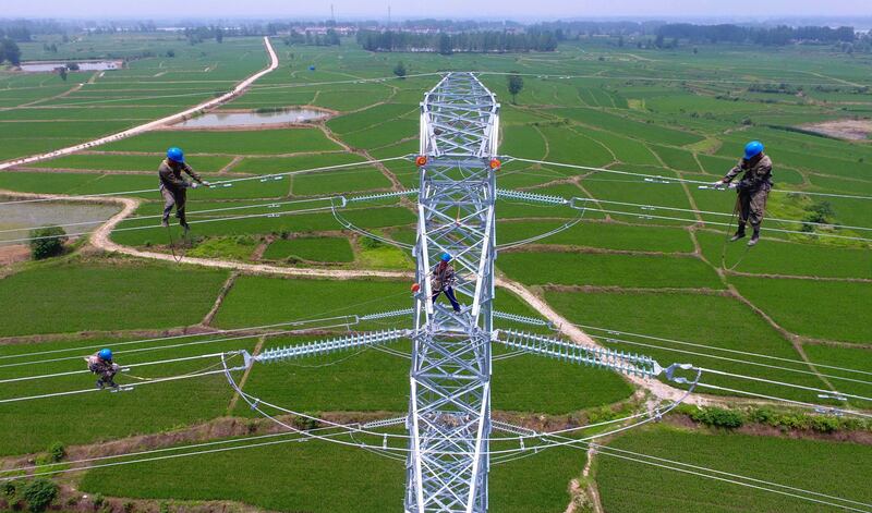 Workers check the power lines in Laian, in China's eastern Anhui province. AFP Photo