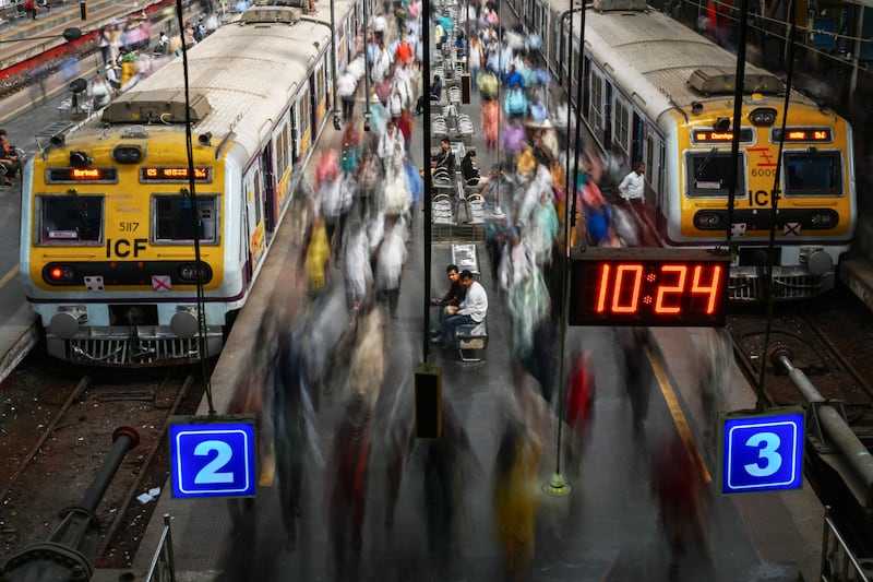 Commuters move along platforms at Churchgate railway station in Mumbai, India. AFP