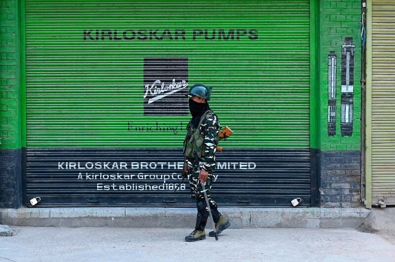 An Indian paramilitary trooper stands guard in front of closed shops during a lockdown in Srinagar.  AFP