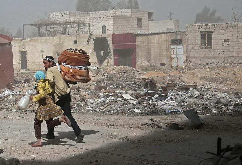 Syrians run for cover in Hamouria during Syrian government shelling on rebel-held areas in the Eastern Ghouta region on the outskirts of the capital Damascus on March 6, 2018. Abdulmonam Eassa / AFP