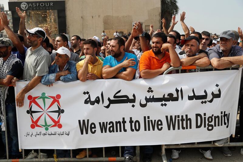 Palestinian refugees hold a banner as hundreds of refugees request asylum at a rally outside the the Canadian Embassy, in Beirut, Lebanon. AP