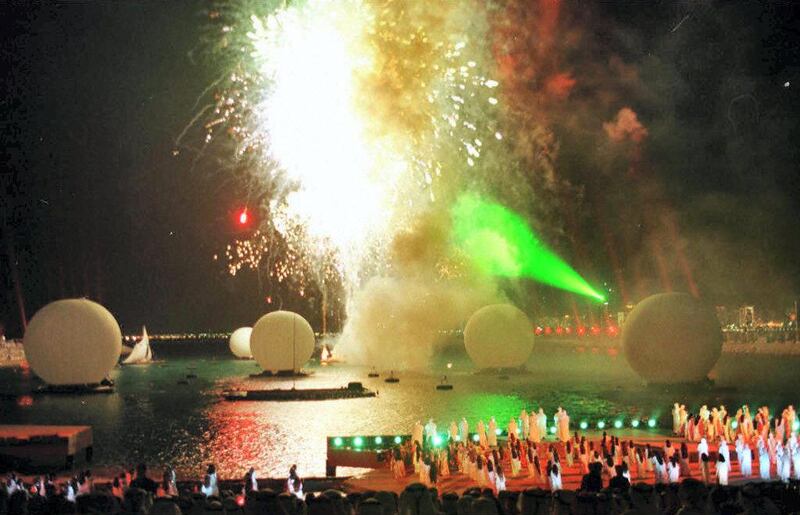 Fireworks burst 03 December over the water as Emiratis present a traditional dance on a beach in Abu Dhabi during opening ceremonies for the 11th Asian Nations football cup in the United Arab Emirates. A bitter rivalry between Japan and South Korea threatens to dominate the competition. (Photo by RABIH MOGHRABI / AFP)