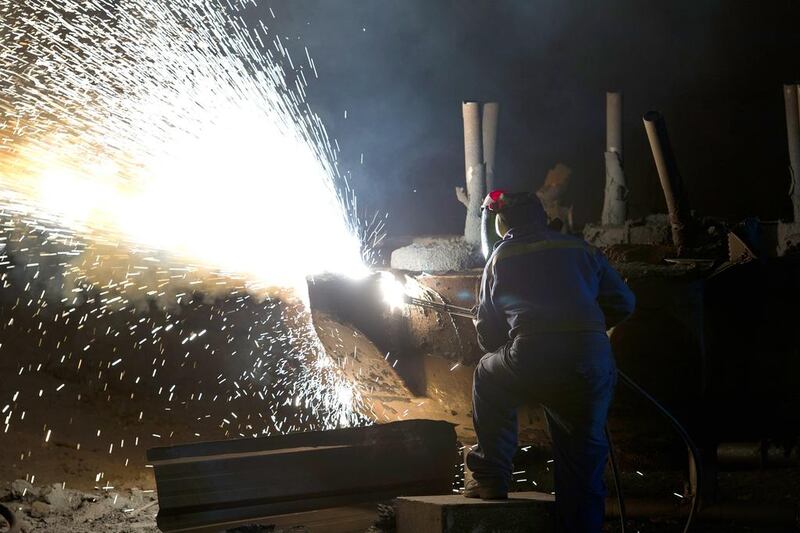 A ‘burner’ works on a piece of freshly cast steel as he works in the foundry at Sheffield Forgemasters. Oli Scarff / AFP