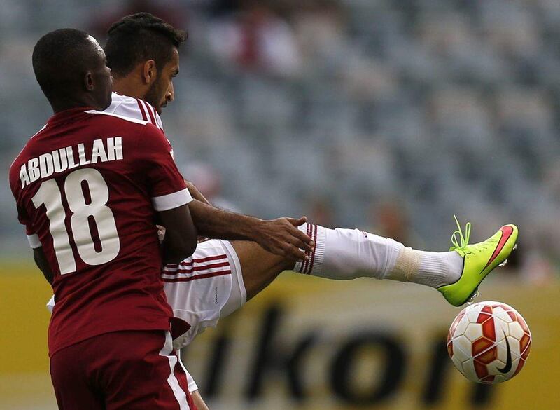 UAE's Ali Mabkhout controls the ball from Qatar's Mohammed Abdullah during their Asian Cup Group C match on Sunday. Tim Wimborne / Reuters