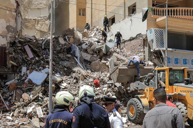 First responders speak with a policeman at the scene of the building collapse. AFP
