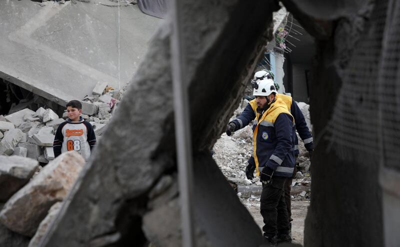 Members of the Syrian Civil Defence (also known as "The White Helmets") clear debris from buildings in Orum al-Kubra, Syria. AFP