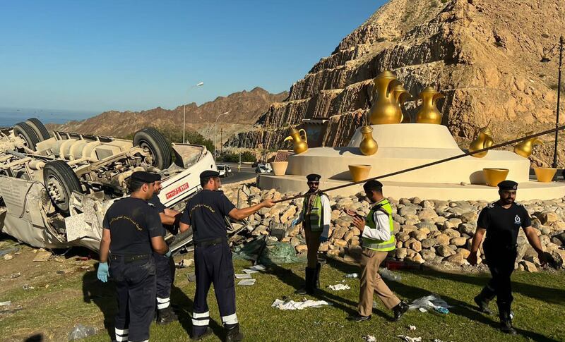 Rescuers and police officers at the accident scene, in Muscat