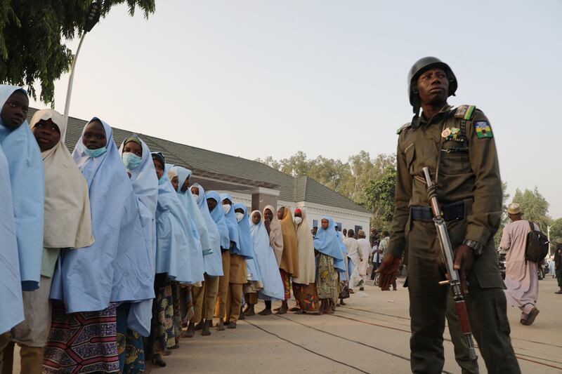 A soldier stands next to a group of girls previously kidnapped from their boarding school in northern Nigeria. AFP