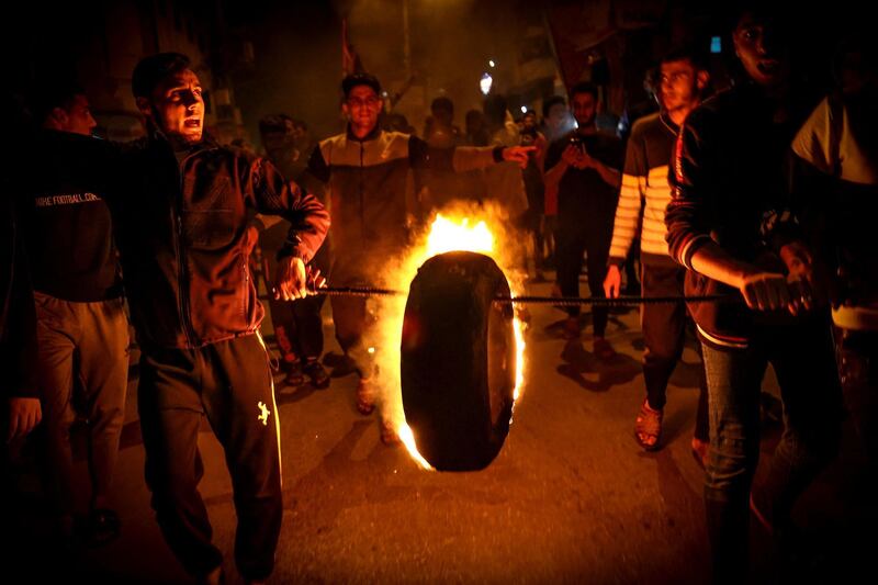 Palestinians parade a burning tyre as they shout slogans in support of the Al-Aqsa Mosque during a rally in Gaza city, condemning overnight clashes in Israeli-annexed east Jerusalem. AFP