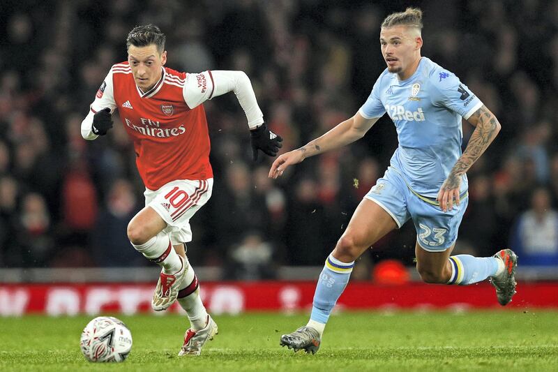 Arsenal's German midfielder Mesut Ozil (L) runs away from Leeds United's English midfielder Kalvin Phillips (R) during the English FA Cup third round football match between Arsenal and Leeds United at The Emirates Stadium in London on January 6, 2020. (Photo by Adrian DENNIS / AFP) / RESTRICTED TO EDITORIAL USE. No use with unauthorized audio, video, data, fixture lists, club/league logos or 'live' services. Online in-match use limited to 120 images. An additional 40 images may be used in extra time. No video emulation. Social media in-match use limited to 120 images. An additional 40 images may be used in extra time. No use in betting publications, games or single club/league/player publications. / 