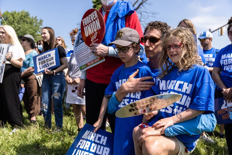 Matt Swerdlin kneels with his children during a June March For Our Lives event in Buffalo. Getty Images / AFP
