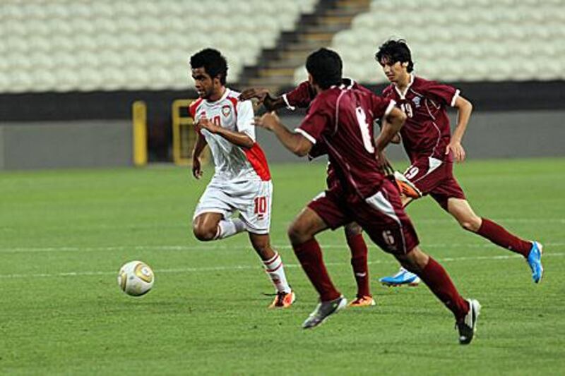 Abdullah Salem, left, of the UAE is on the run as three Qatar players give chase at Mohammed bin Zayed Stadium in Abu Dhabi.