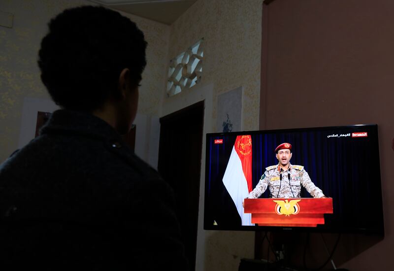 A viewer watches a TV statement by Houthi military spokesman Yahya Saree, who said five of the group's fighters were killed and six wounded in 73 air strikes carried out by the US and UK in Yemen. EPA