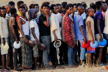 Ethiopian men who fled war in Tigray region queue for wet food ration at the Um Rakoba camp, on the Sudan-Ethiopia border in Al Qadarif state, Sudan. Reuters