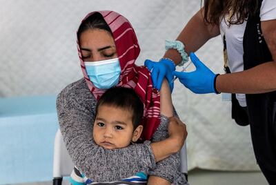 A migrant holds her baby as she receives a shot of the Johnson & Johnson vaccine against the coronavirus disease (COVID-19) in the Mavrovouni camp for refugees and migrants on the island of Lesbos, Greece, June 3, 2021. REUTERS/Alkis Konstantinidis     TPX IMAGES OF THE DAY