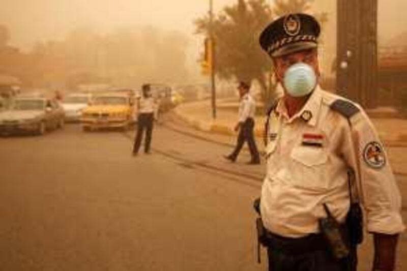 Iraqi policemen wear dust masks as they direct traffic during a sand storm in central Baghdad, Iraq, Sunday, June 28, 2009. Sandstorms are a regular occurrence in Baghdad although it is shielded from the desert by a thin strip of arable land between the Tigris and Euphrates rivers. (AP Photo/Hadi Mizban) *** Local Caption ***  BAG101_Iraq_Sand_Storm.jpg *** Local Caption ***  BAG101_Iraq_Sand_Storm.jpg