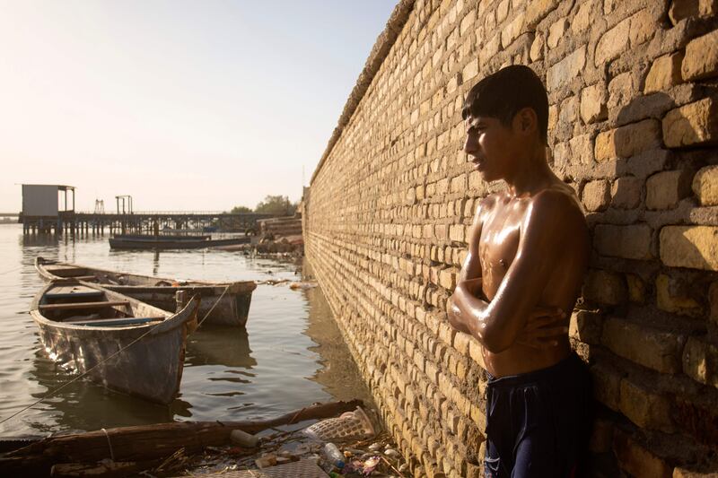 A boy stands by the waters of the Shatt Al Arab waterway.