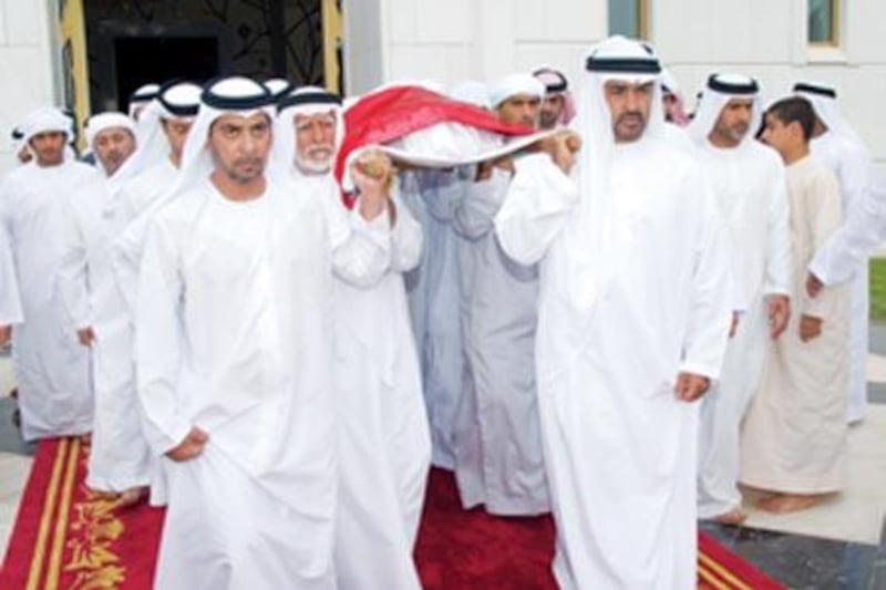 Sheikh Mohammed bin Zayed, Crown Prince of Abu Dhabi and Deputy Supreme Commander of the UAE Armed Forces, centre right, and Sheikh Hamdan bin Zayed, the Ruler's Representative in the Western Region and Chairman of the Environment Agency, centre left, carry the body of Sheikh Ahmed bin Zayed with their brothers and family.