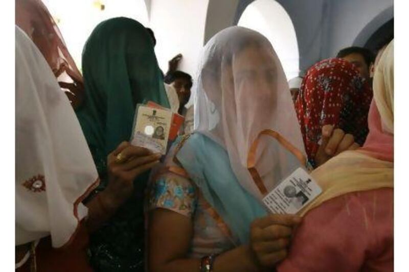 Women wait to cast their votes in the Indian state of Haryana last year. Indians in the UAE are pressing for a provision of absentee ballots. Manish Swarup / AP Photo