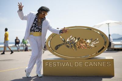 Elvis Presley impersonator Eryl Prayer poses on the Croisette near an installation of a  Palme d'Or symbol ahead of the screening of the film 'Elvis' at the Cannes Film Festival on May 25. Reuters 