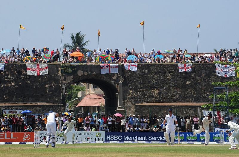 (FILES) In this file photo taken on March 27, 2012 England cricket team fans watch the second day of the opening Test match between Sri Lanka and England from the top of the 17th century Dutch fort overlooking Galle Stadium in Galle. Sri Lanka's picturesque Galle cricket stadium could be demolished because its pavilion stand violated heritage laws protecting a 17th century Dutch fort, the government said July 20, 2018.
 / AFP / Lakruwan WANNIARACHCHI
