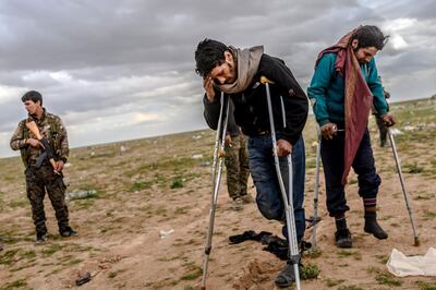 TOPSHOT - Men suspected of being Islamic State (IS) fighters wait to be searched by members of the Kurdish-led Syrian Democratic Forces (SDF) after leaving the IS group's last holdout of Baghouz, in Syria's northern Deir Ezzor province on February 27, 2019.  / AFP / Bulent KILIC
