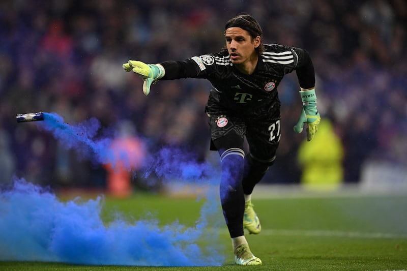 Bayern Munich goalkeeper Yann Sommer throws a smoke bomb from his goalmouth. AFP