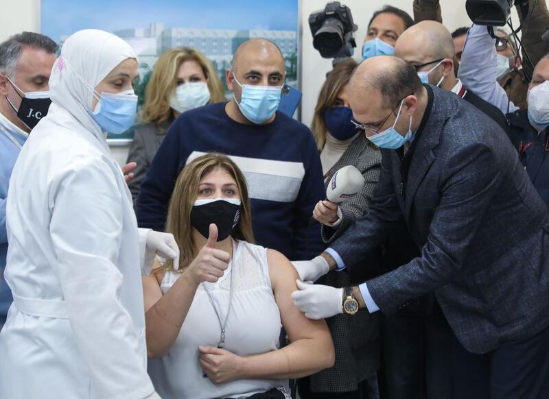 Lebanon's caretaker Health Minister Hamad Hassan administers a dose of the Covid-19 vaccine to a member of the healthcare staff at the Rafik Hariri Hospital in the capital Beirut as the country started its inoculation campaign on Sunday. AFP