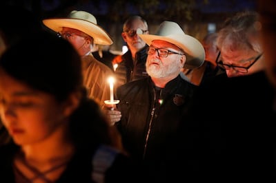 Stephen Willeford, center, who confronted and exchanged gunfire with the Sutherland Springs church shooter in 2017, joins church and community members gathered outside West Freeway Church of Christ for a candlelight vigil, Monday, Dec. 30, 2019, in White Settlement, Texas. A gunman shot and killed two people before an armed security officer returned fire, killing him during a service at the church on Sunday. (Tom Fox/The Dallas Morning News via AP)