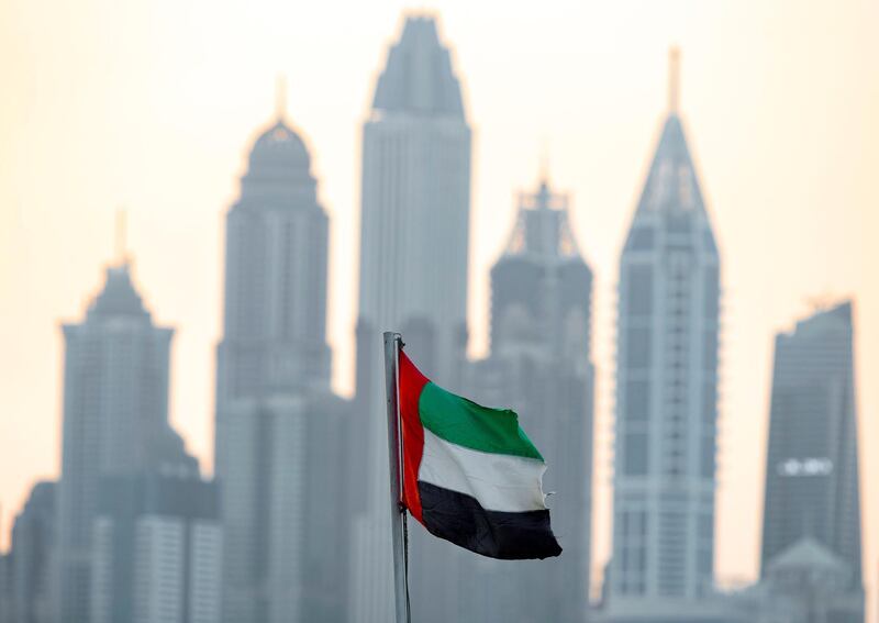 Dubai, United Arab Emirates - November 01, 2019: Standalone for Flag day. The UAE flag blows in the wind with the skyscrapers of Dubai Marina in the background. Friday the 1st of November 2019. Dubai. Chris Whiteoak / The National