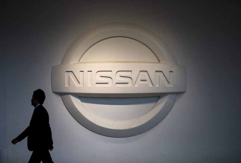A man walks past a logo of Nissan Motors at the company’s headquarters in Yokohama on May 14, 2019. / AFP / Behrouz MEHRI
