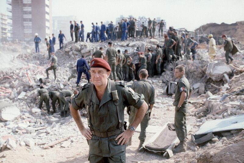 General François Cann , commander of the french troops of the multinational forces answers newsmen as rescuers search for survivors 25 October 1983 in Beirut through the rubble of the -Drakkar- building which was destroyed by a suicide truck bomber overnight, 23 October 1983. Fifty-eight French soldiers and five Lebaneses were killed in the attack. The troops were part of the FMSB, (Beirut security multinational force) that was installed to keep security in the Lebanese capital after the Israeli invasion of 1982. AFP PHOTO PHILIPPE BOUCHON (Photo by PHILIPPE BOUCHON / AFP)