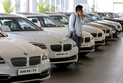 FILE PHOTO: A man takes a look at second-hand BMW cars at a dealer shop in Beijing, China, September 11, 2015.  REUTERS/Kim Kyung-Hoon/File Photo
