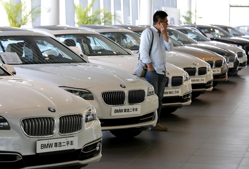 FILE PHOTO: A man takes a look at second-hand BMW cars at a dealer shop in Beijing, China, September 11, 2015.  REUTERS/Kim Kyung-Hoon/File Photo