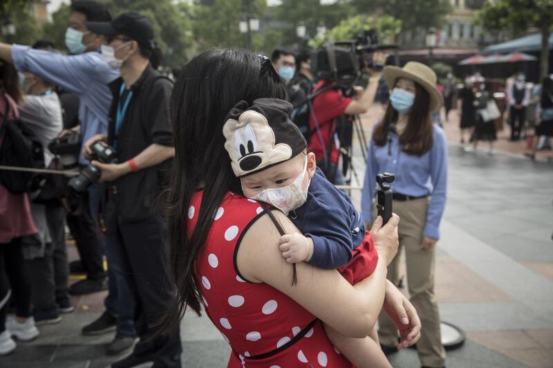 One of the Shanghai Disneyland's youngest visitors wears a face mask and a Mickey Mouse hat.  Bloomberg