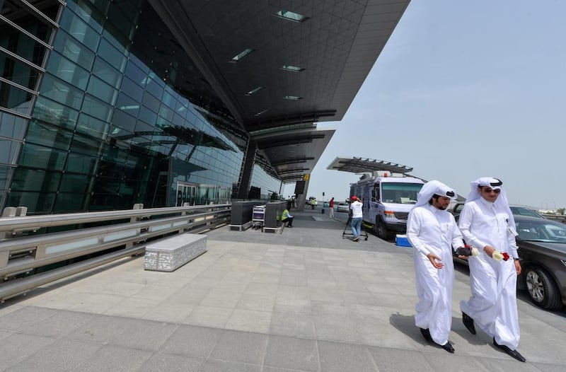 People walk in front of Hamad International Airport in Doha, Qatar. Etihad is to suspend flights to Doha. EPA