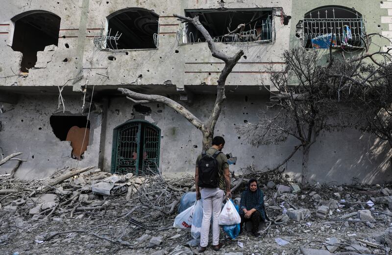 Palestinians in Al Remal neighbourhood, which was destroyed in Israeli air strikes on Gaza. EPA