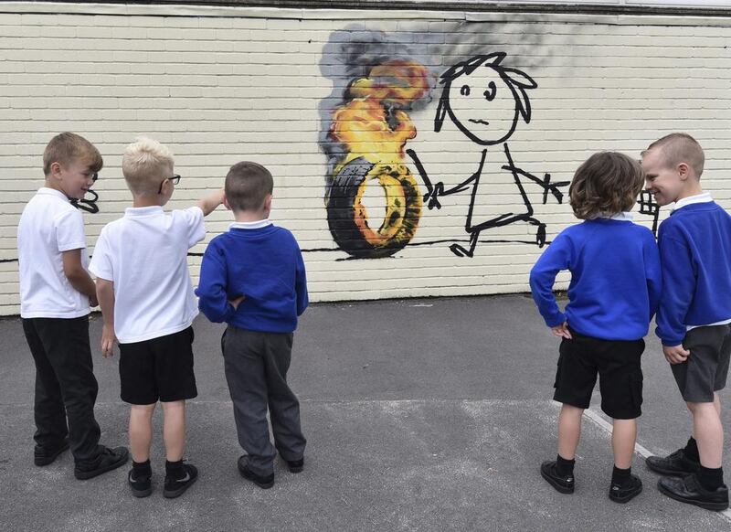 Children from Bridge Farm Primary School look at Banksy authenticated mural. Neil Munns / EPA