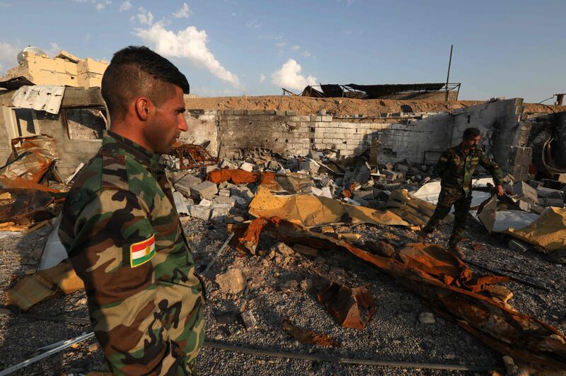 Kurdish peshmerga fighters assess the destruction caused by a reported Iranian rocket attack near the town of Altun Kupri in Iraq's autonomous Kurdistan region. AFP