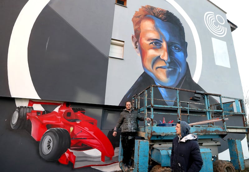 Bosnian artists work on a mural depicting former seven-time Formula One champion Michael Schumacher in Dobrinja, Sarajevo, on Tuesday, January 4, 2022. EPA