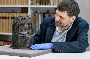 Neil Curtis, head of museums and special collections at the University of Aberdeen, with a Benin bronze depicting the Oba of Benin. University of Aberdeen