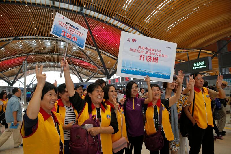 Tourists pose for a photograph at the departure hall in Hong Kong. AP Photo