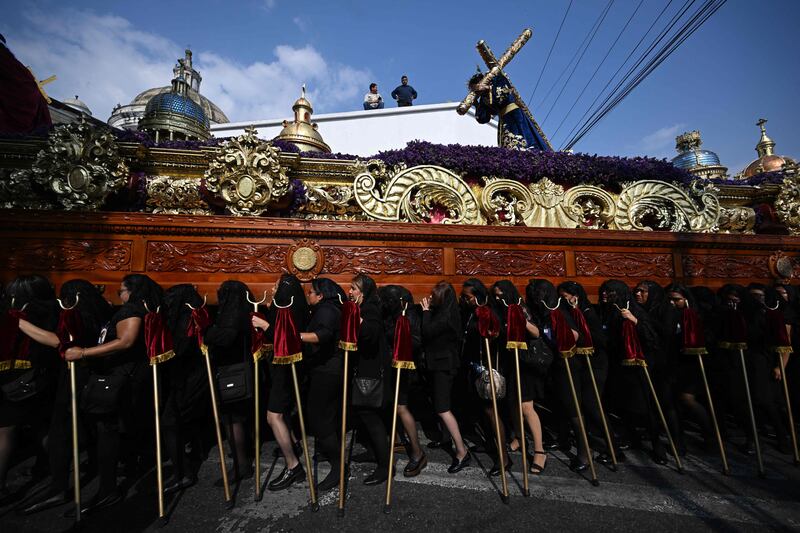 Women carry the procession float of the Virgin of Sorrows through the streets of Guatemala City. AFP