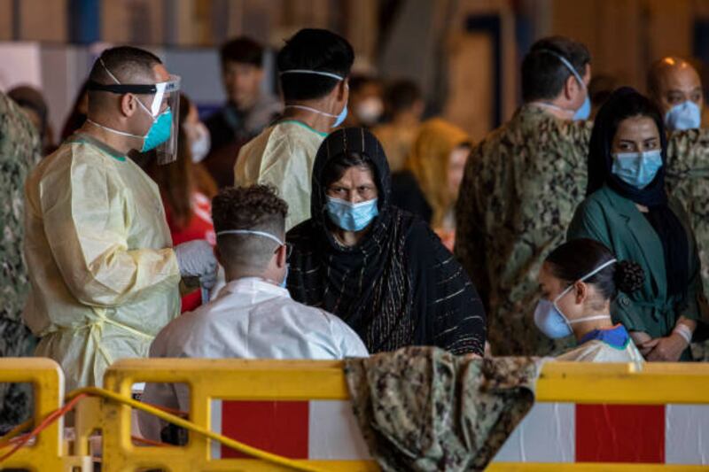 Health workers prepare to perform Covid-19 tests for Afghan evacuees after disembarking from a US Air Force plane at Rota Naval Base in Spain. Getty Images