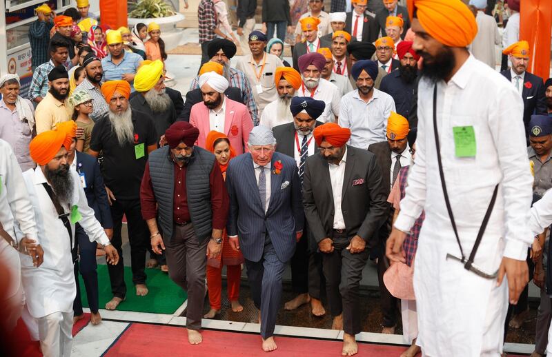 Britain's Prince Charles, centre, arrives at Gurudwara Bangla Sahib, a Sikh Temple in New Delhi, India, Wednesday, Nov. 13, 2019. Prince Charles visited the Sikh temple to participate in celebrations of the 550th birth anniversary of Sikh Guru, Baba Guru Nanak, and mark the contribution of the Sikh community in Britain. During his two day visit he is also meeting with Indian experts focusing on global challenges such as business sustainability and climate change. AP